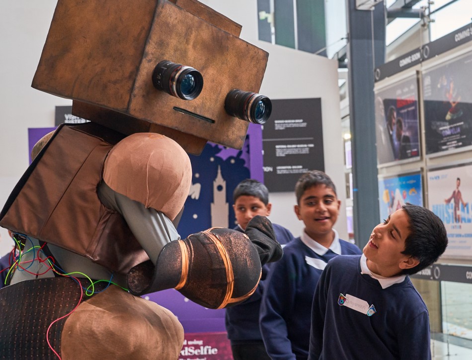 Children pose with a robot at the Young People's Book Prize award ceremony in 2019